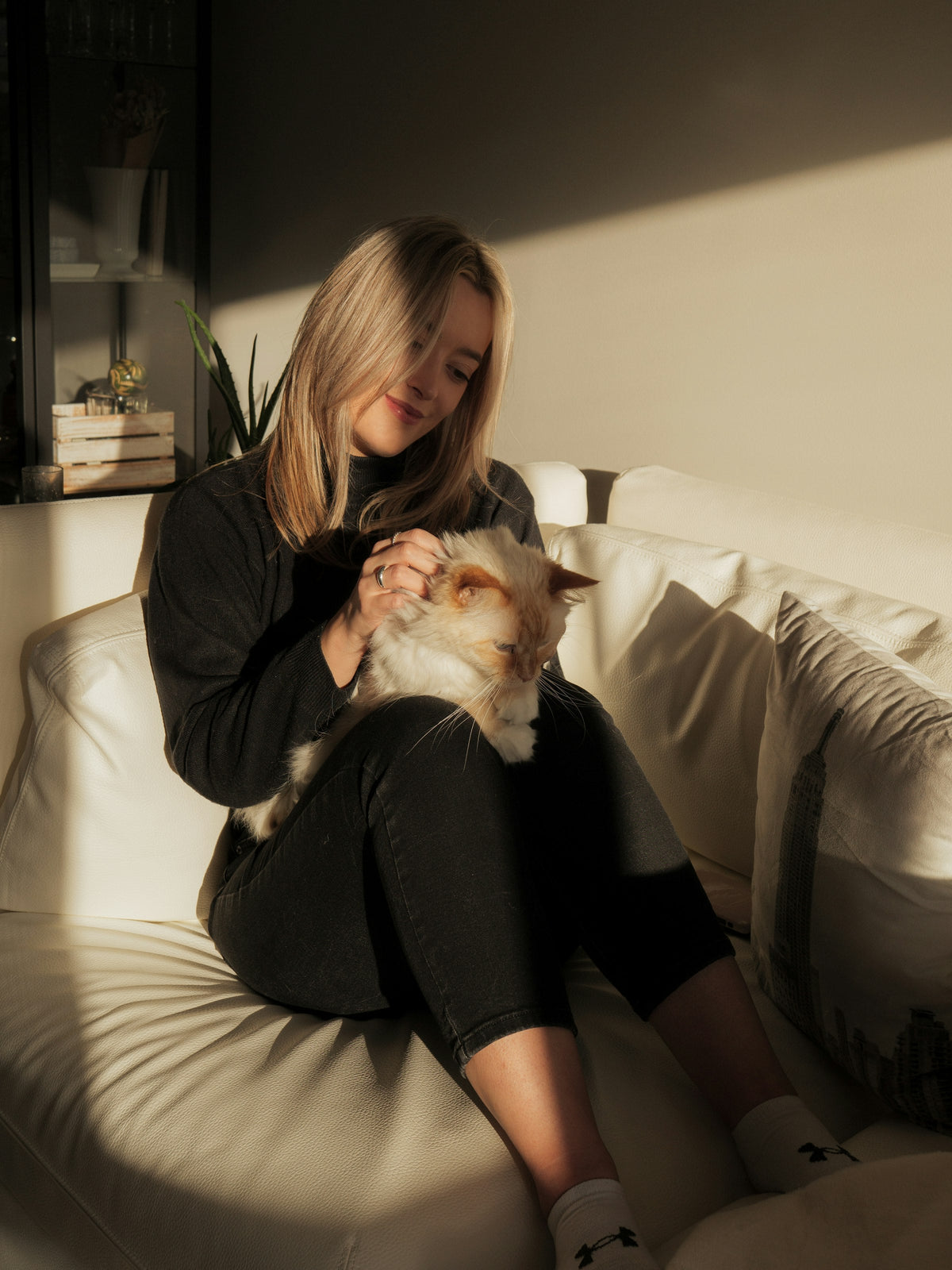 Woman resting her head beside her grey cat